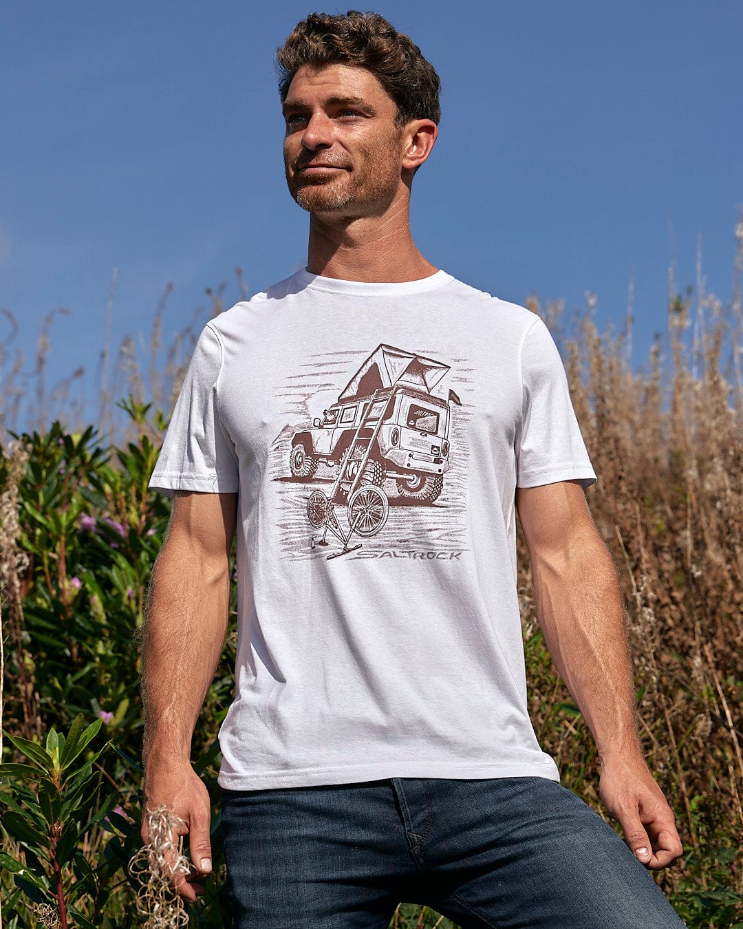 A man wearing a Saltrock Tent Truck - Mens Short Sleeve T-Shirt - White, featuring a graphic of a camper truck, perfect for outdoor enthusiasts.