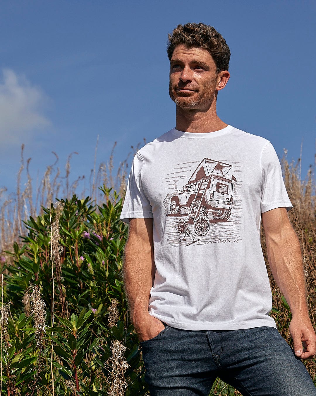 A man wearing a Saltrock Tent Truck Mens Short Sleeve T-Shirt - White standing outdoors.