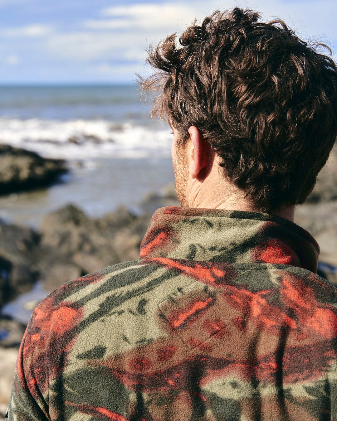 A man wearing a Saltrock Terran - Mens Zip Thru Fleece - Green/Red featuring a utility pocket on the chest.