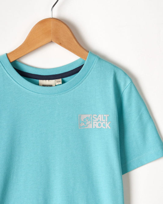 A light blue basic Tok Corp recycled kids short sleeve t-shirt in teal with the Saltrock branding logo on the chest, hanging on a wooden hanger against a white background.