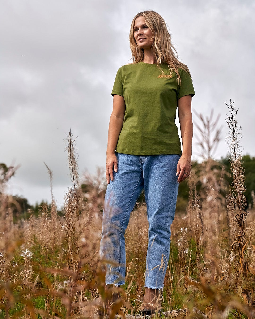 A woman in a green Saltrock t-shirt showcasing Saltrock branding and lightweight fabric.