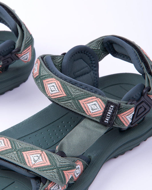 Pair of Saltrock Trail - Womens Sandals - Green with geometric straps and a black logo label, displayed on a white background.