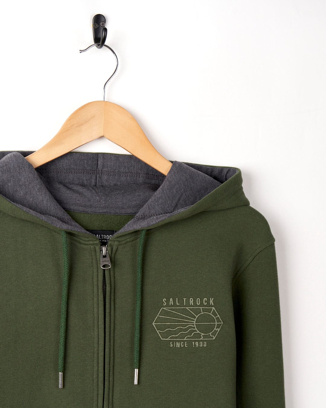 Dark Green Vantage Outline - Recycled Mens Zip Hoodie with white "Saltrock since 1988" embroidered branding, hanging on a wooden hanger against a white background.