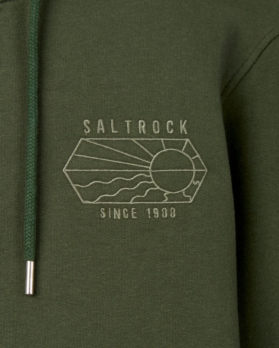 Close-up of a green Saltrock Vantage Outline - Recycled Mens Zip Hoodie - Dark Green with the "Saltrock since 1993" embroidered branding on it, next to a zipper with a metal pull.