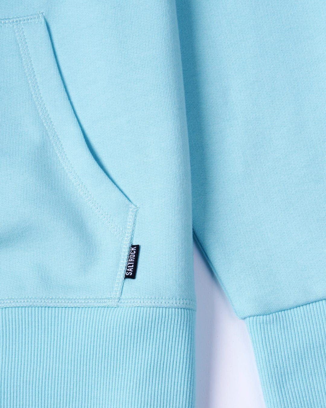 Close-up of a light blue Velator - Womens Pop Hoodie - machine washable fabric with a visible Saltrock branding label on the seam.