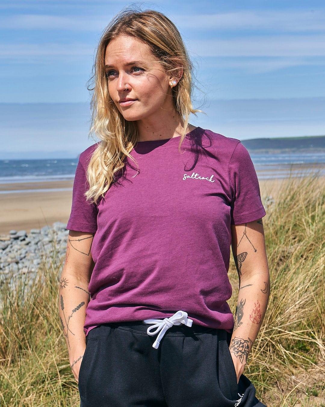 A woman wearing a Saltrock Velator - Womens Short Sleeve T-Shirt - Dark Purple and black pants.