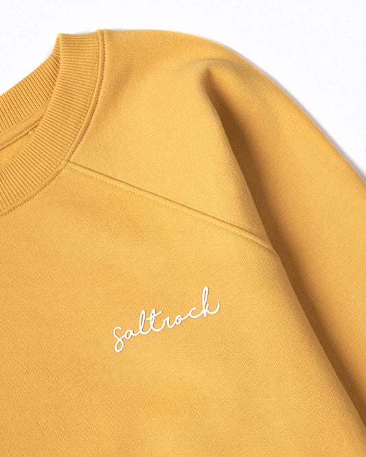 Close-up of a Velator mustard yellow sweatshirt with a crew neckline and the word "Saltrock" embroidered in white on the front.