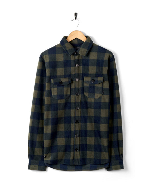 A Waldron - Mens Fleece Shirt - Dark Green flannel shirt hanging on a black wall hook against a white background.