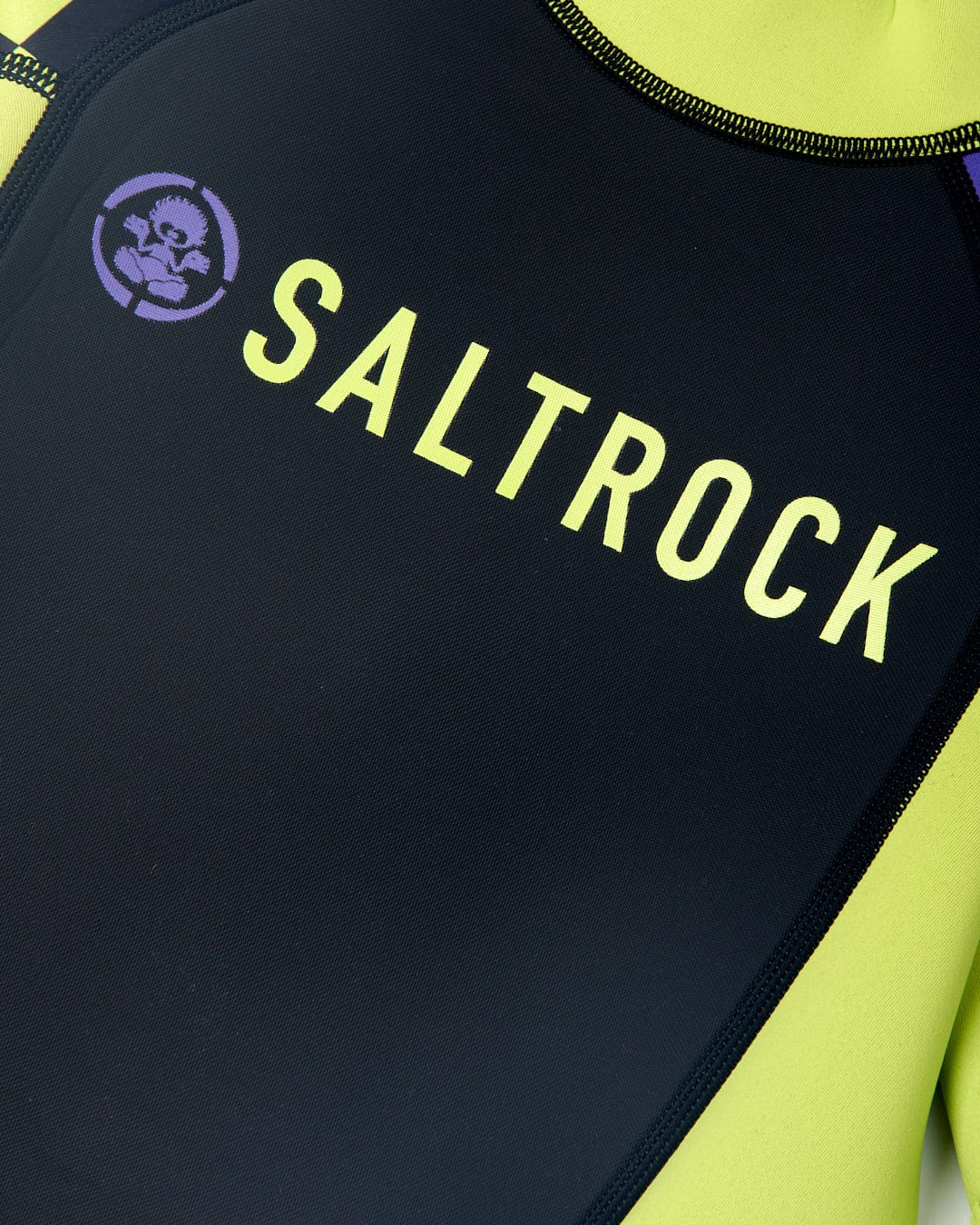Close-up of a black and neon yellow Warped - Kids 3/2 Back Zip Wetsuit by Saltrock with the brand name and logo visible.