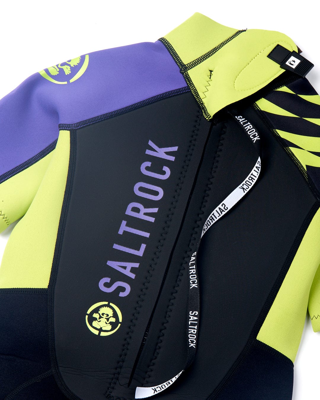 A close-up view of a Saltrock Warped Kids 3/2 Back Zip Wetsuit in black with neon green colors and company logos on the chest and arm.