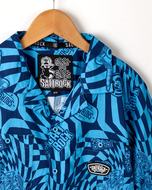A Warp Icon - Kids Short Sleeve Shirt - Blue with a geometric print, hanging on a hanger. (Saltrock)