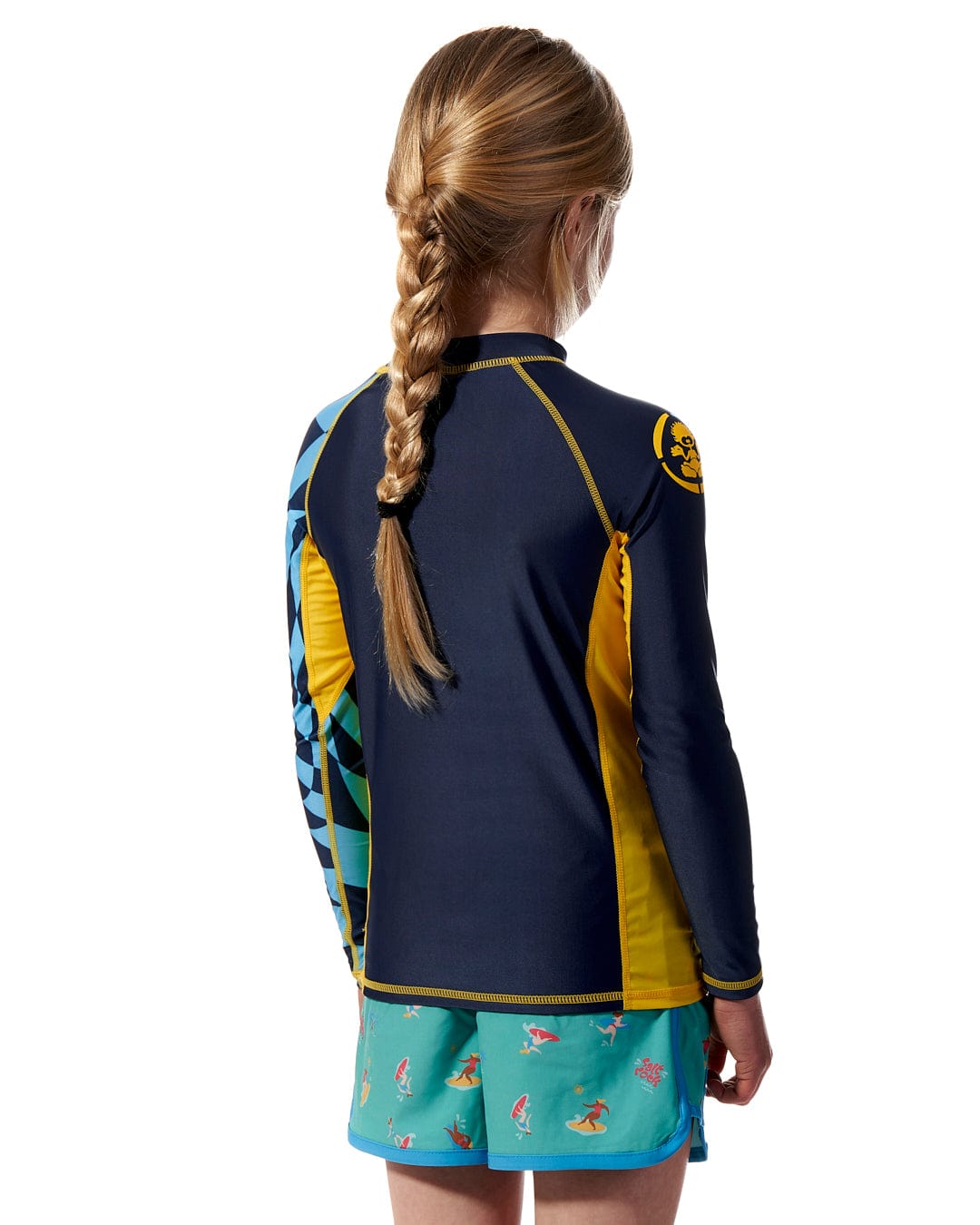 The back view of a girl wearing a Saltrock Warp - Kids Long Sleeve Rash Vest - Blue.