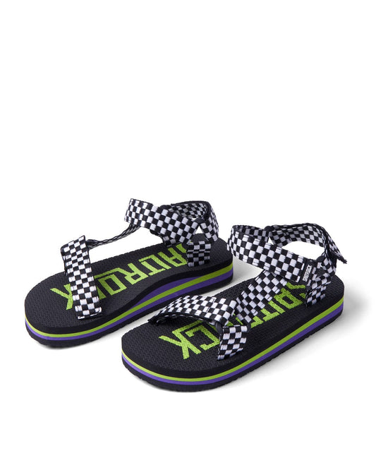 A pair of Saltrock black and white checkered Warp Time kids sandals with green "outdoor" text logo, purple accents, and webbing straps on a white background.