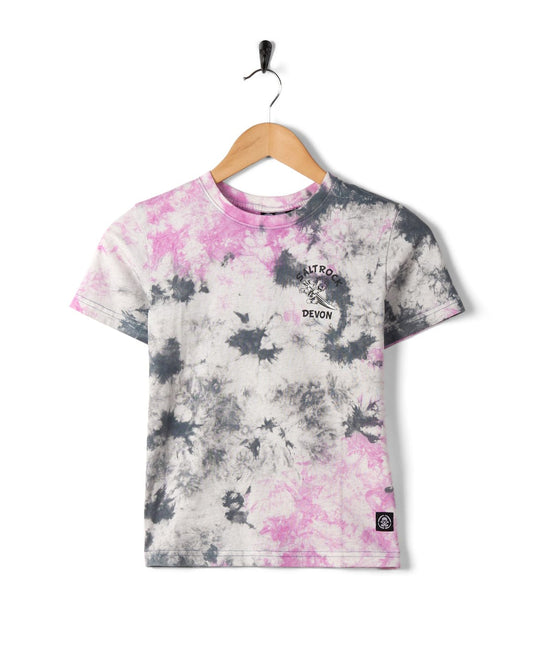 A Wave Rider Devon - Kids Tie Dye Short Sleeve T-Shirt - Pink with pink and black patterns on a white background, hanging on a wall-mounted hanger.