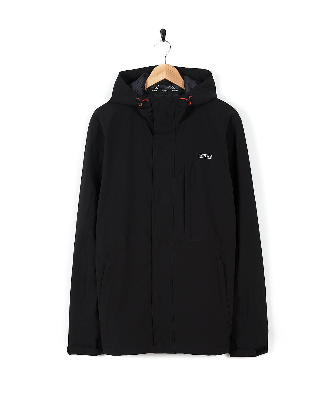 A Saltrock Whistler - Mens Hooded Jacket - Black with zip pockets hanging on a hanger.