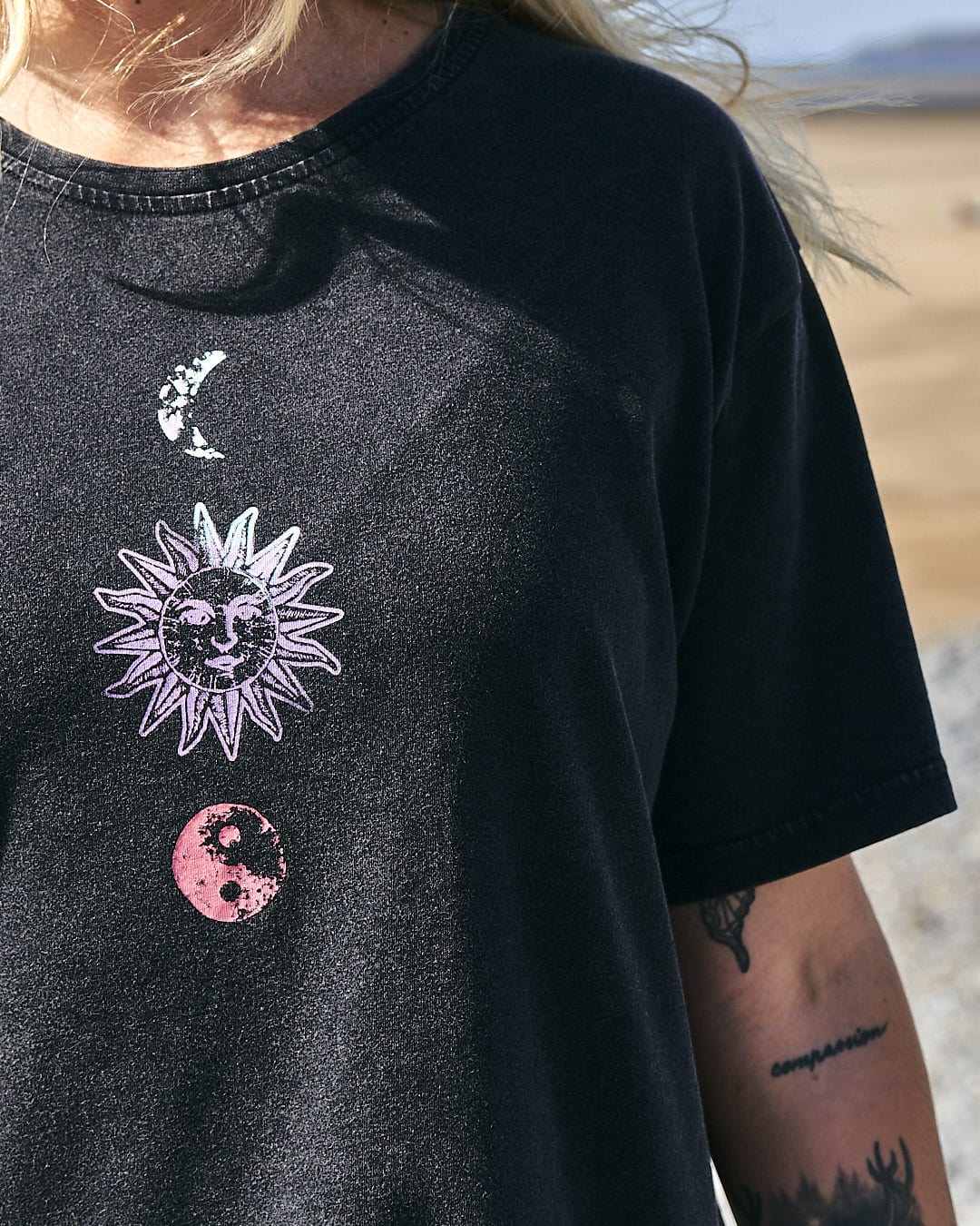 A woman wearing a Saltrock Winter Solstice Gradient - Womens Short Sleeve T-Shirt - Washed Black with a sun and moon on it made of 100% cotton.