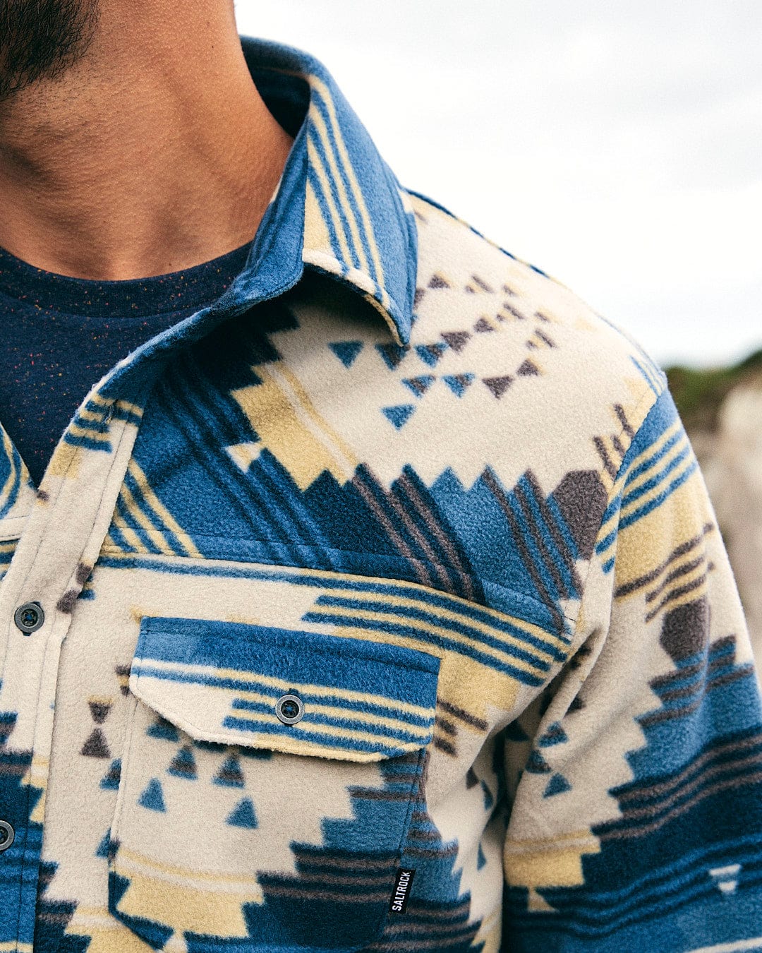 A man wearing a cozy Wolfe - Mens Aztec Fleece Shirt - Blue Saltrock.