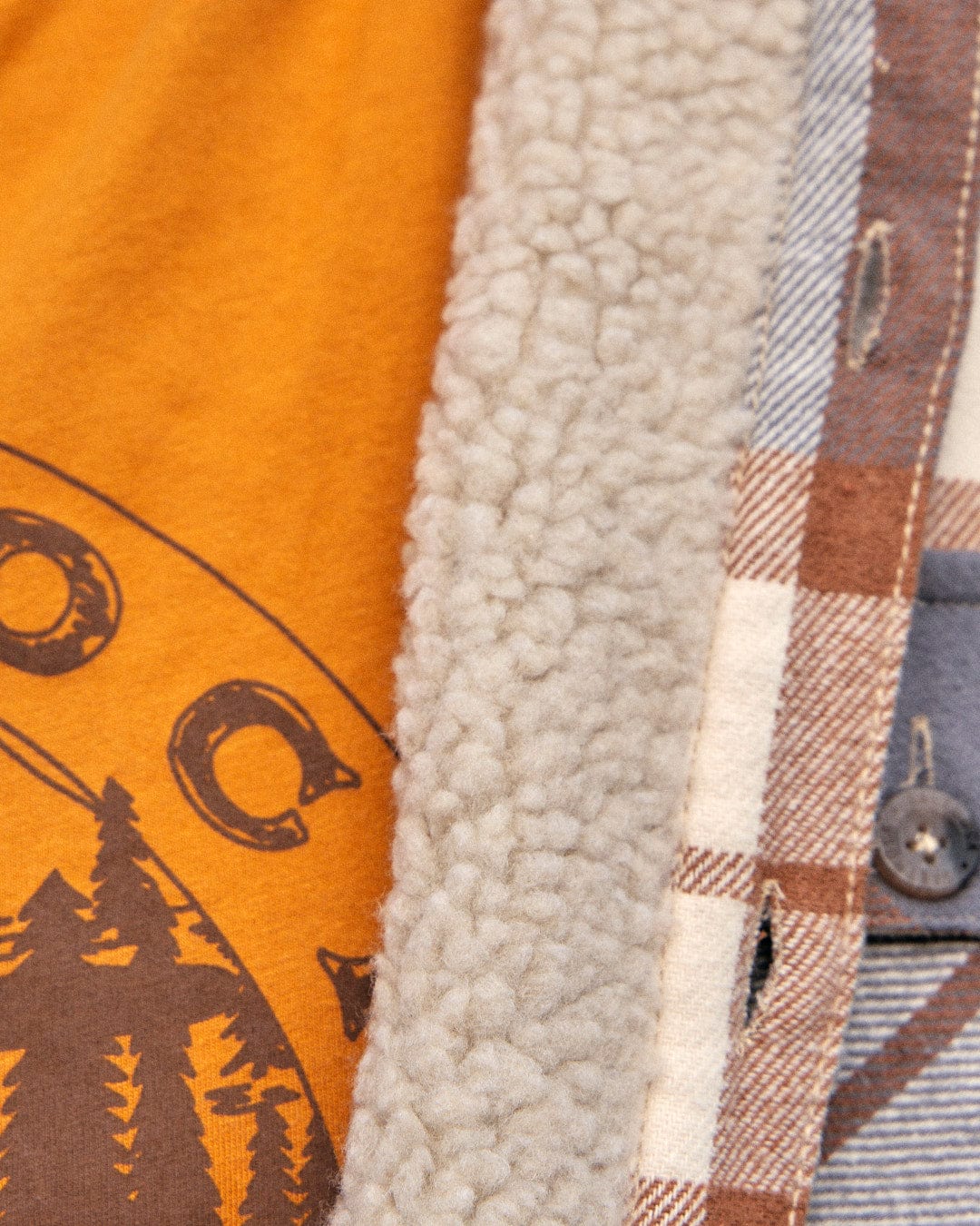 A stylish Woody - Mens Sherpa Lined Shacket - Brown by Saltrock, a warm jacket with a t-shirt layered on top of it.