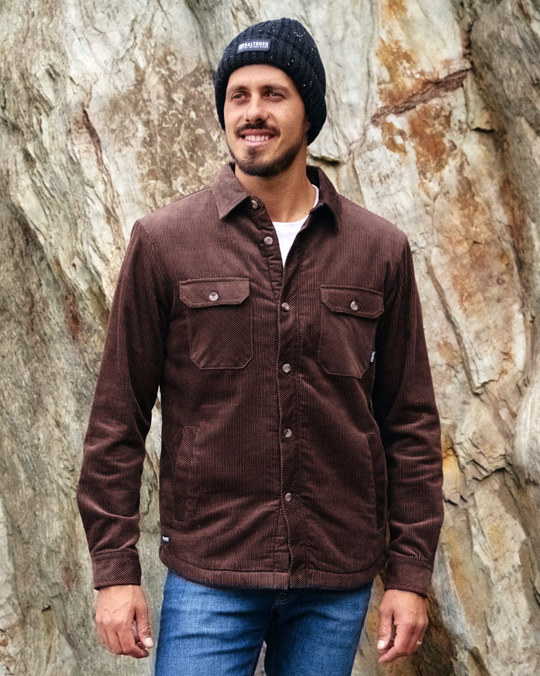 A man wearing a comfortable Saltrock Zeke - Mens Cord Borg Lined Shacket - Dark Brown with style and a beanie.