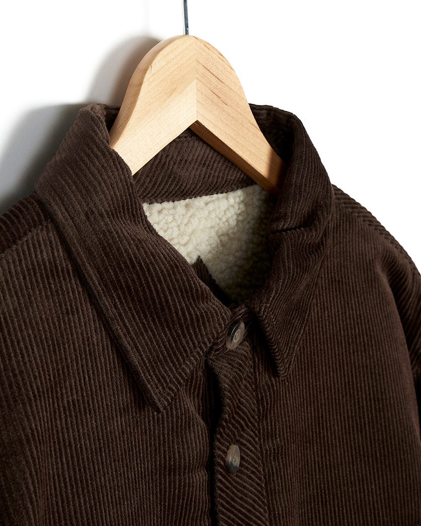 A stylish Saltrock Zeke - Mens Cord Borg Lined Shacket - Dark Brown hanging on a hanger.