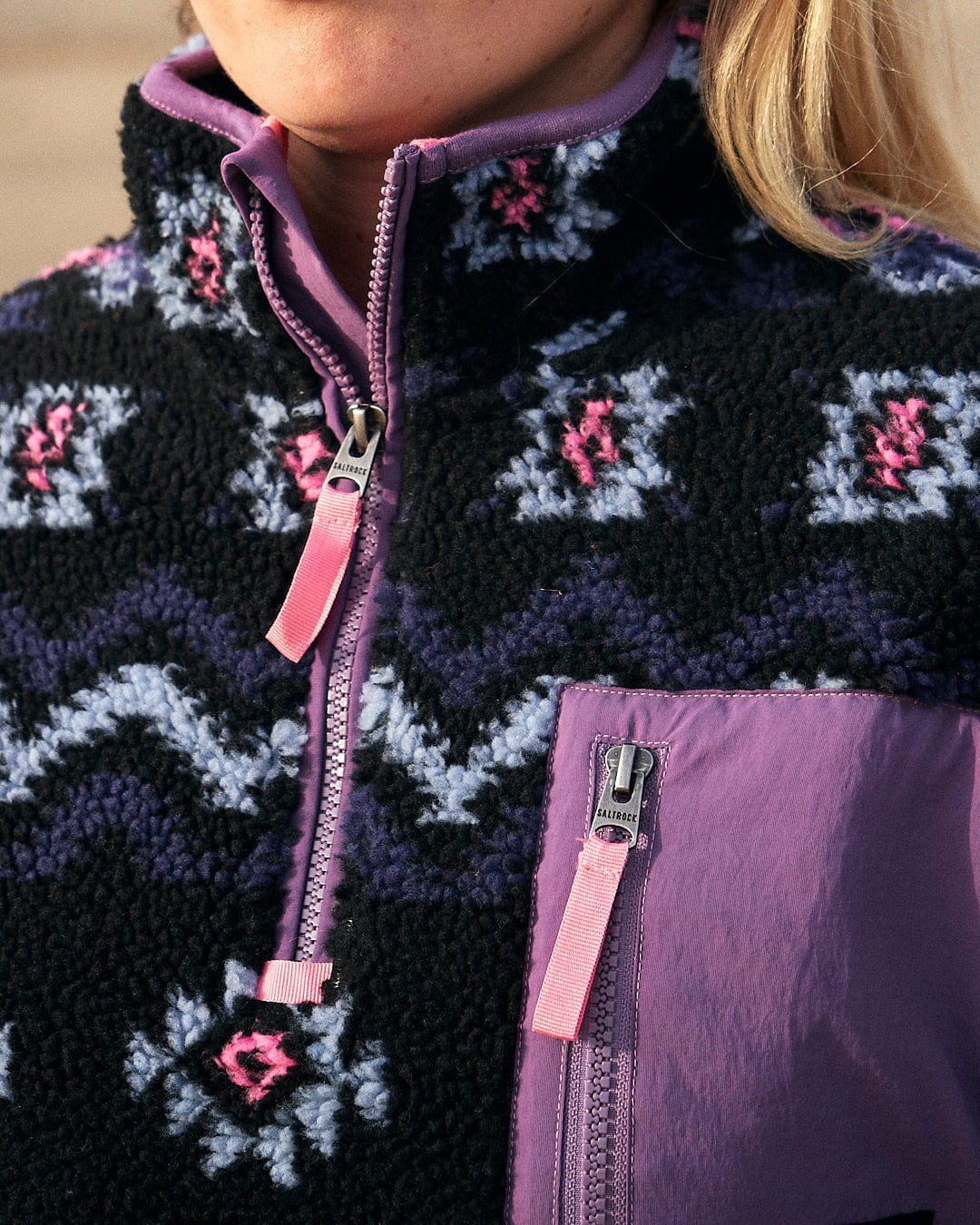 A woman wearing a purple and pink Zella - Womens 1/4 Neck Fleece - Black jacket by Saltrock.