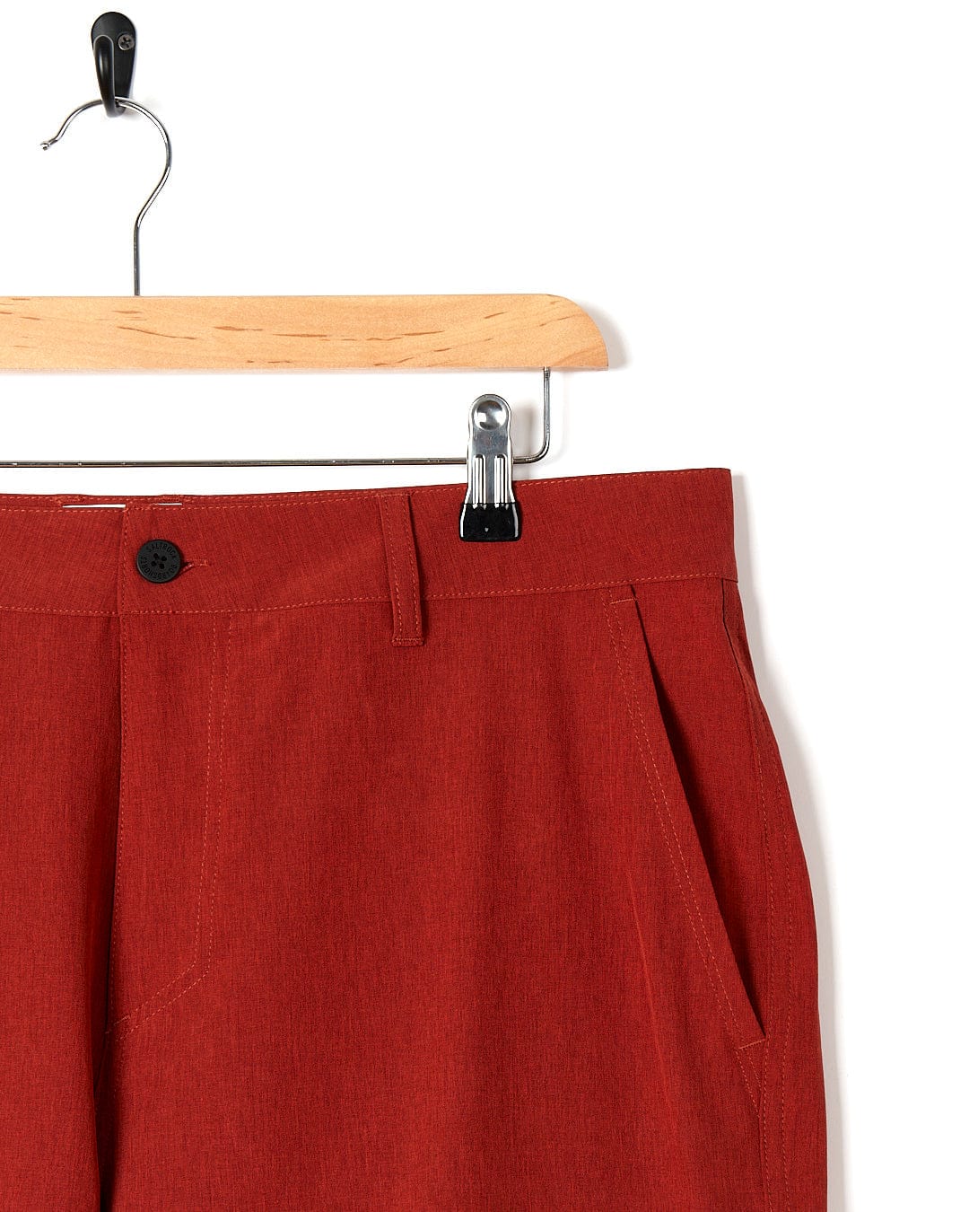 A pair of Saltrock Amphibian II - Mens Boardshort - Red hanging on a hanger.