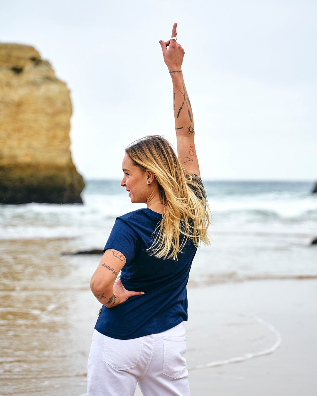 A woman is standing on a beach wearing a Saltrock Celeste Stripe - Womens Short Sleeve T-Shirt - Blue.