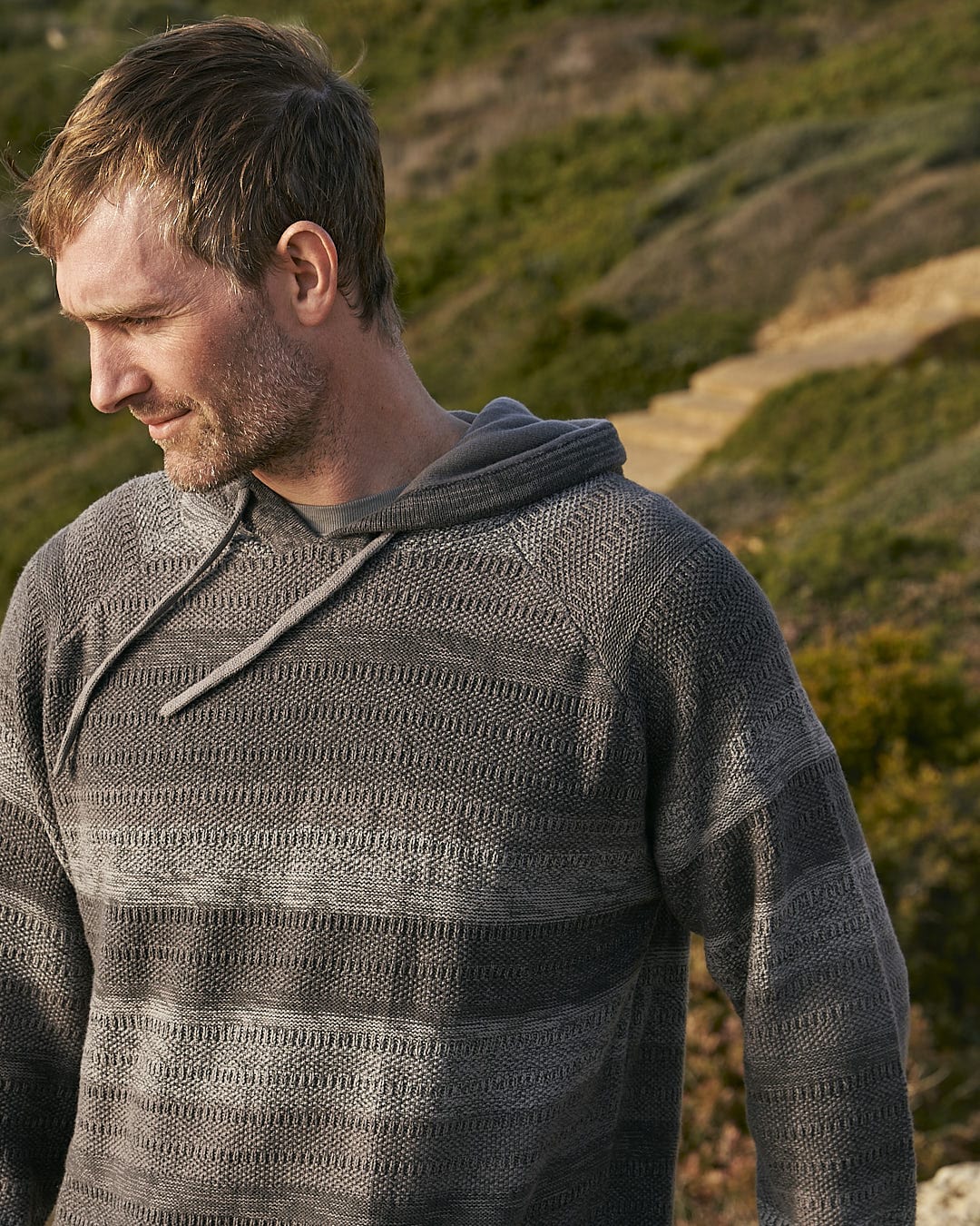 A man wearing a Saltrock Grohl - Mens Knitted Hoodie - Dark Grey sweater.