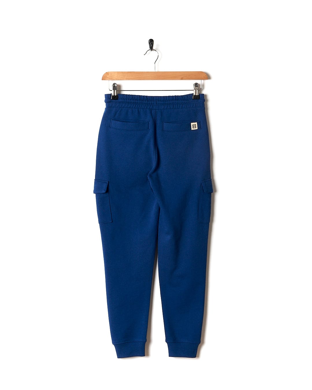 A Jakub - Kids Cargo Trouser - Blue by Saltrock hanging on a hanger.