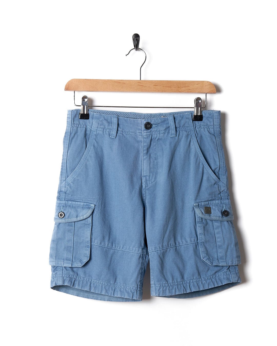 A pair of Saltrock Kaleb - Kids Cargo Shorts - Light Blue hanging on a hanger.