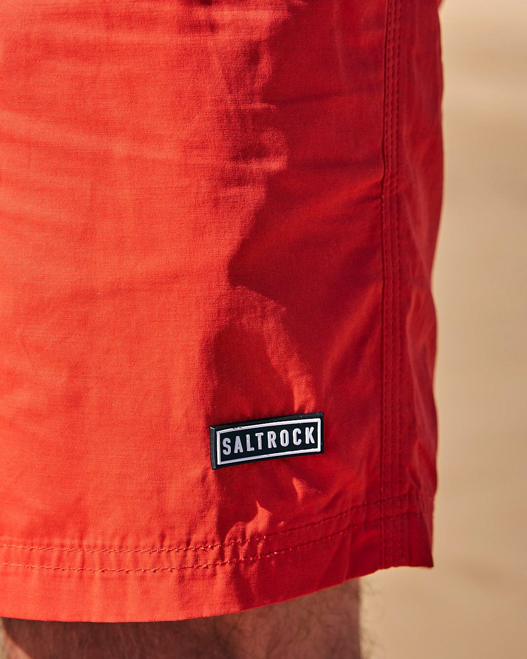 A man wearing Lee - Mens Sueded Volley Swimshort - Red from Saltrock on the beach.