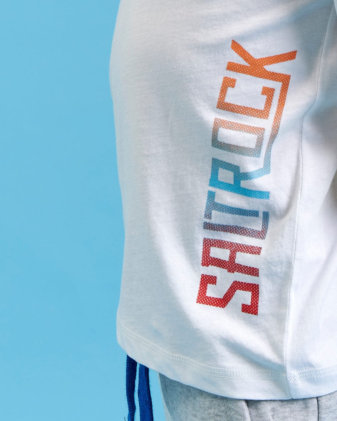The back of a boy wearing a Saltrock Marcus - Kids Long Sleeve Dip Dye T-Shirt - White with the word rock on it.