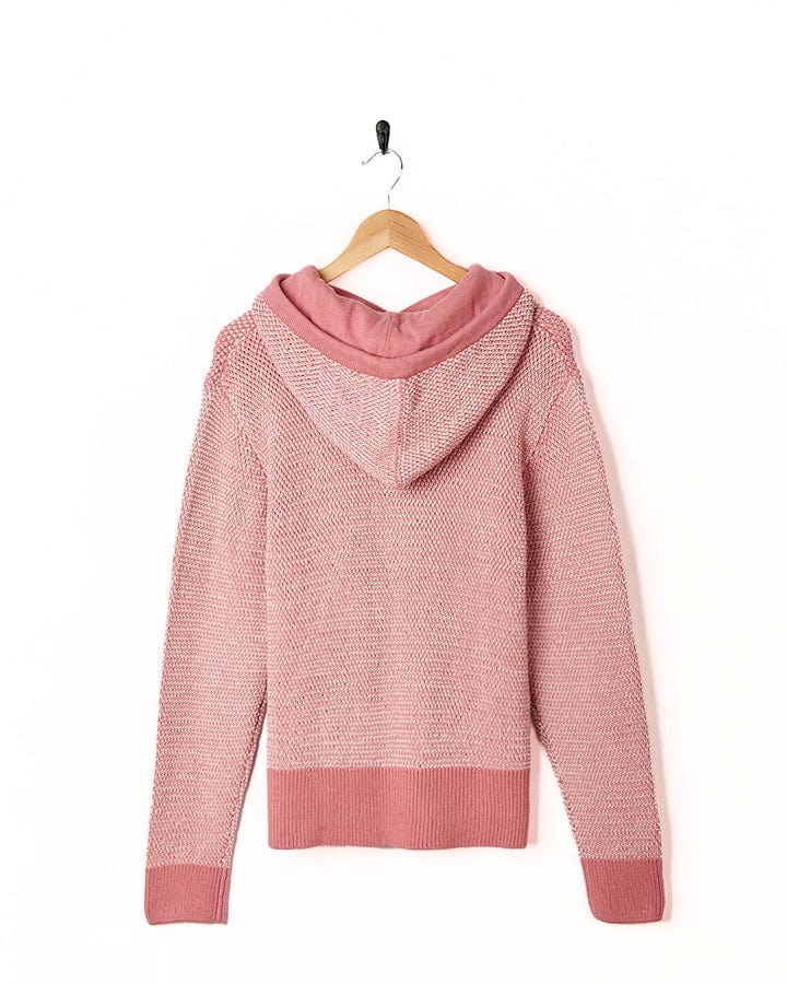 A Poppy - Womens Knitted Pop Hoodie - Mid Pink by Saltrock hanging on a hanger.