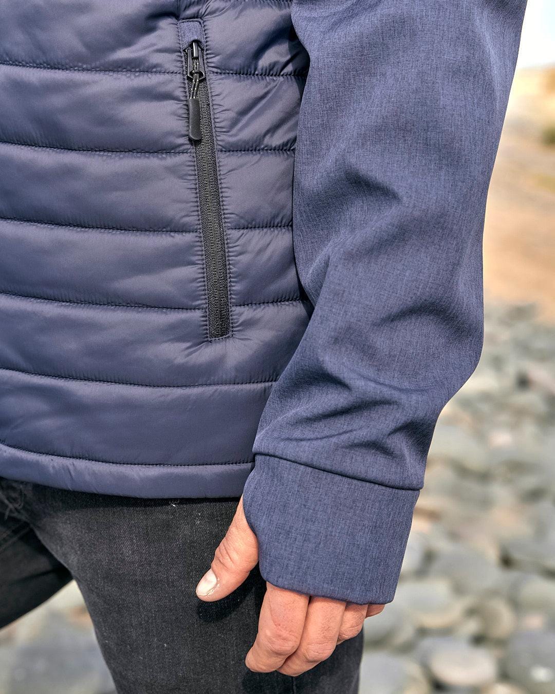 The back of a man wearing a Saltrock Purbeck Padded Jacket - Dark Blue.