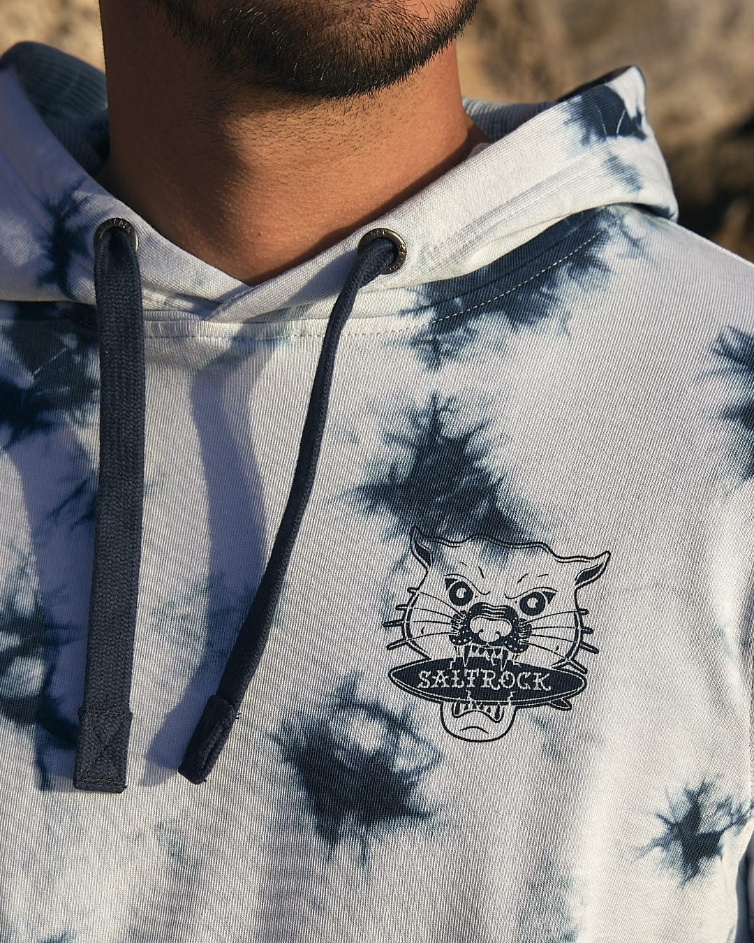 A man wearing a Purfect Wave - Mens Tie Dye Pop Hoodie - Light Blue with a cat on it.