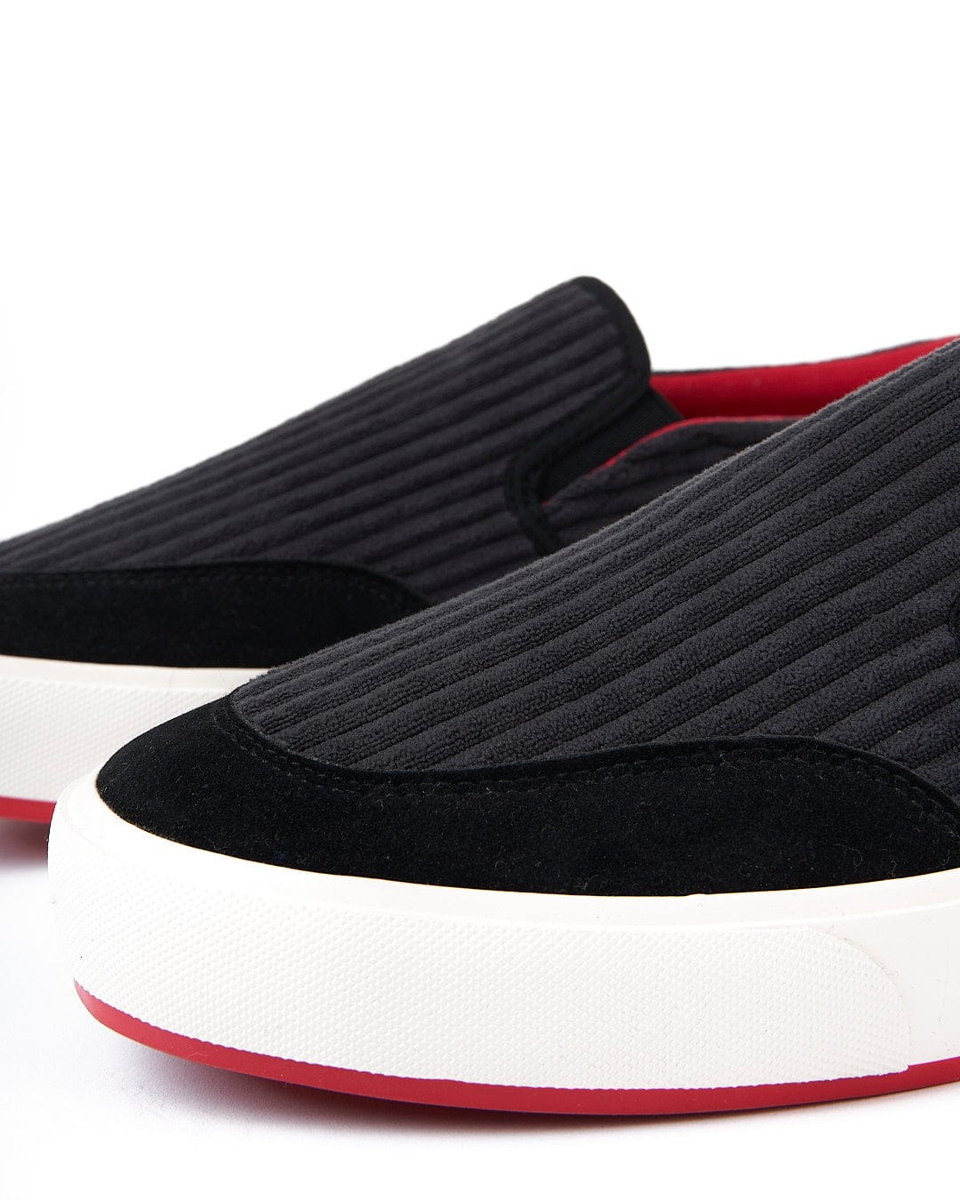 A pair of Rockslide slip on sneakers with red soles.