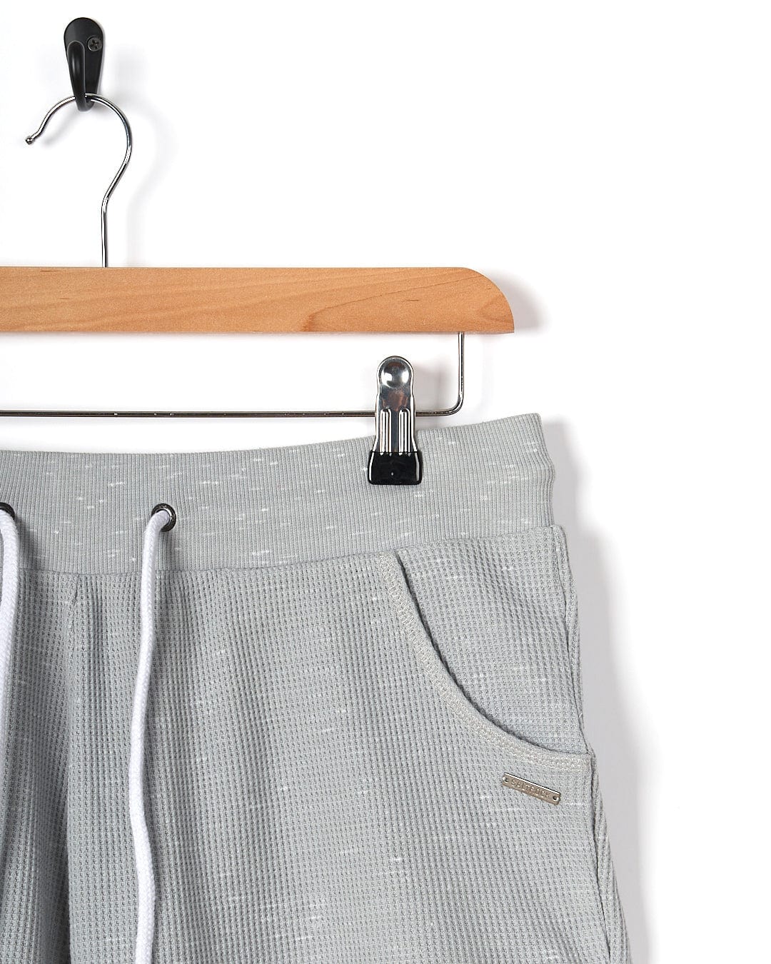 A pair of Rosalin - Womens Sweat Short - Light Grey by Saltrock hanging on a hanger.