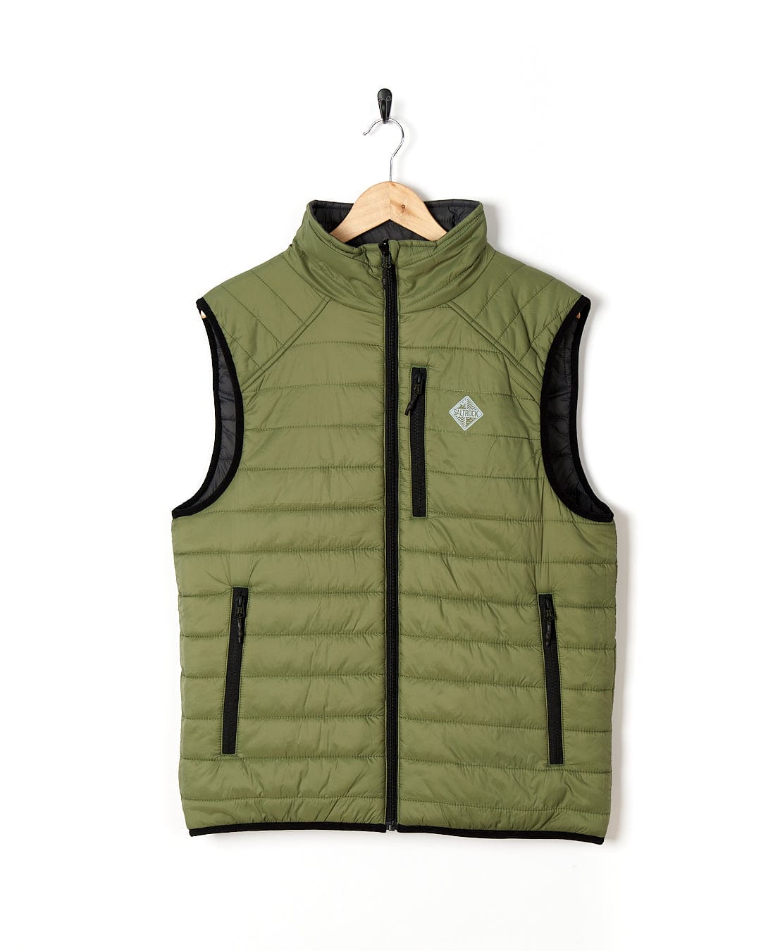 The Saltrock - Mens Reversible Gilet - Dark Green/Black is hanging on a hanger.