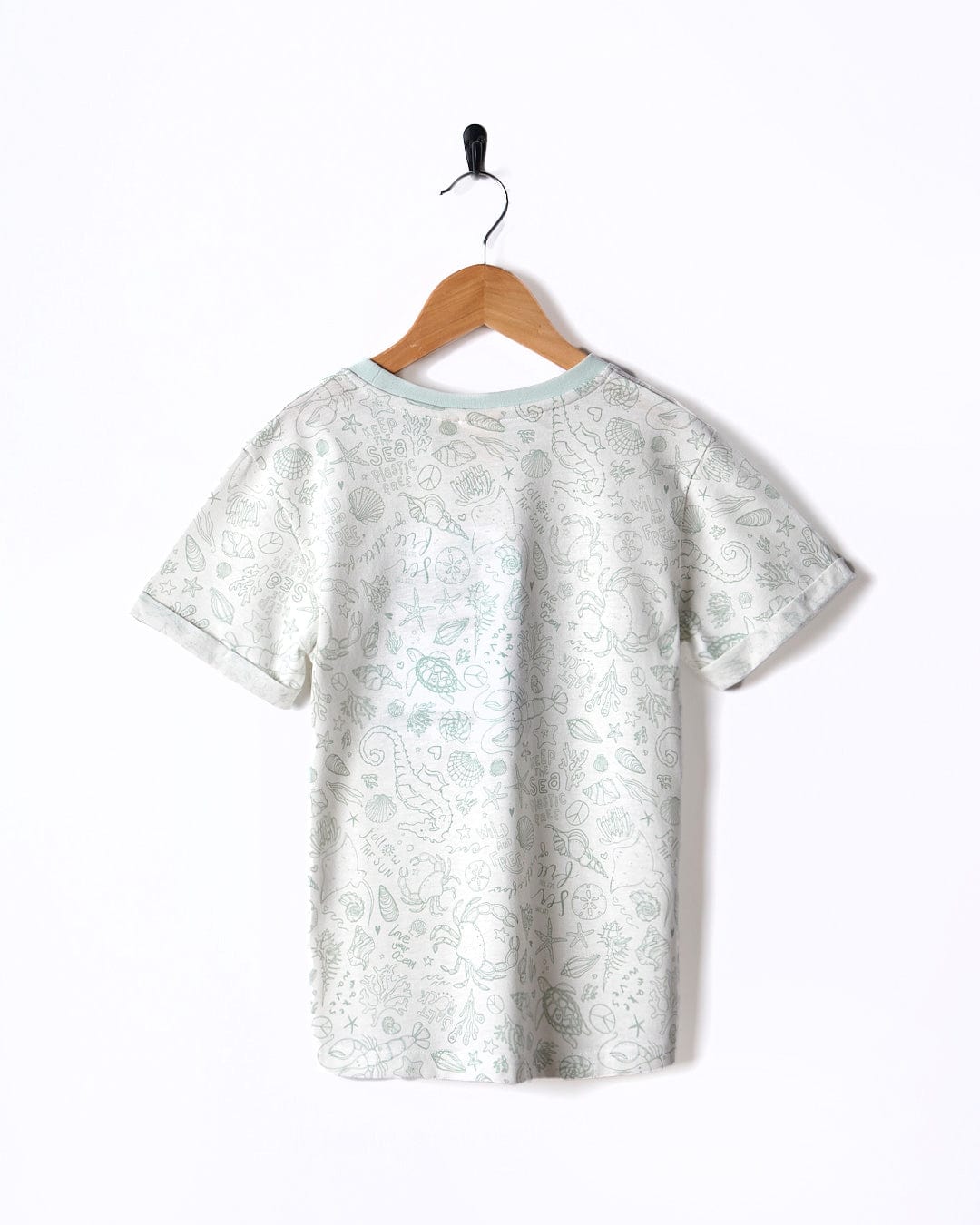 A Seashore - Kids All Over Print Short Sleeve T-Shirt - White hanging on a wooden hanger. (Brand: Saltrock)