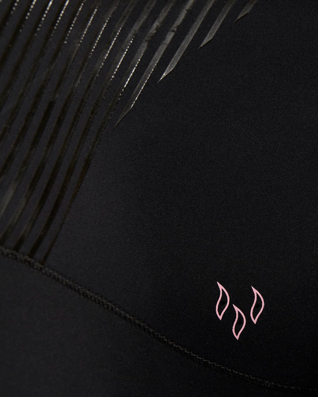 A close up of a Saltrock Shockwave - Womens 3/2 Front Zip Full Wetsuit - Black with a pink logo.