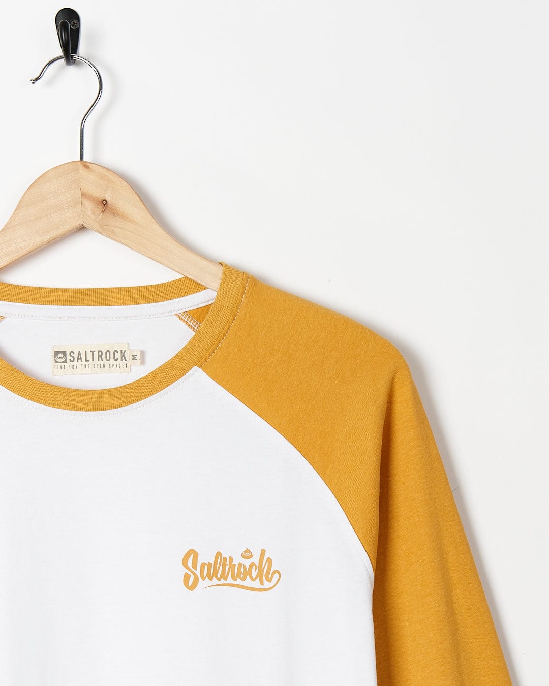 A white and yellow Saltrock Speed - Mens Long Sleeve Raglan T-Shirt - Ochre/White hanging on a hanger.