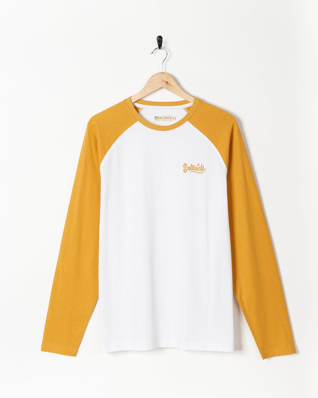 A Saltrock Speed - Mens Long Sleeve Raglan T-Shirt - Ochre/White hanging on a wall.