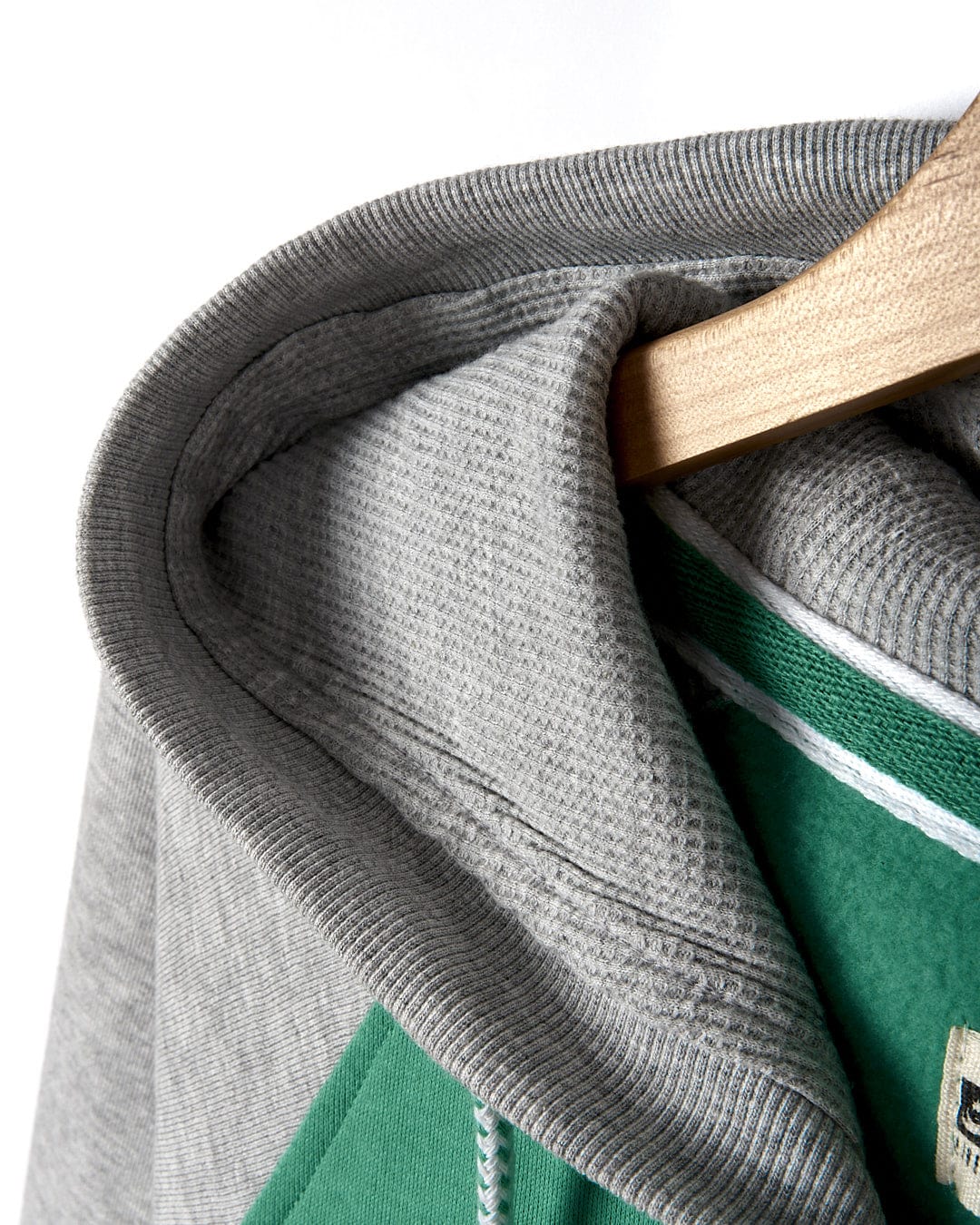 A Stencil - Mens Zip Hoodie - Green Saltrock hoodie hanging on a hanger.