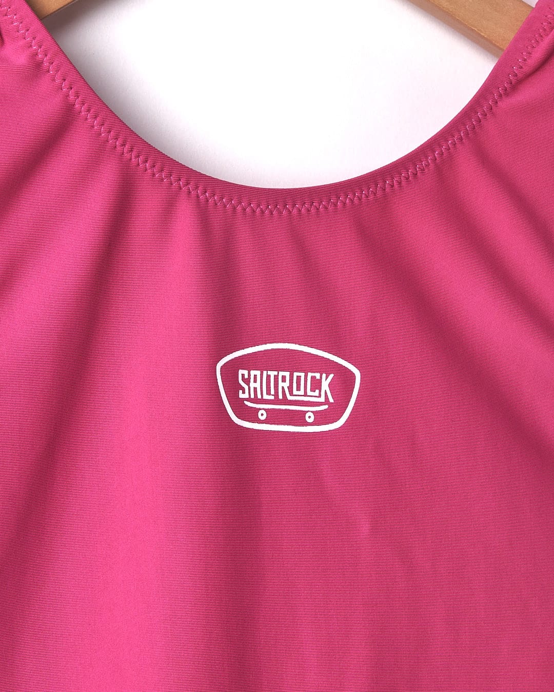 A Sunny - Kids Swimsuit - Pink by Saltrock with a white logo on it.