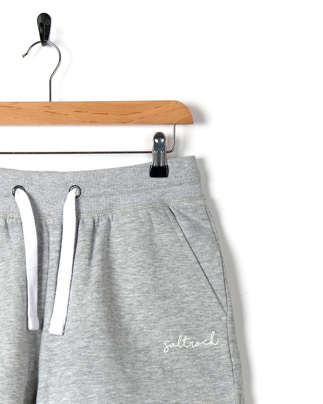 A pair of Saltrock Velator - Womens Sweat Shorts - Light Grey hanging on a hanger.