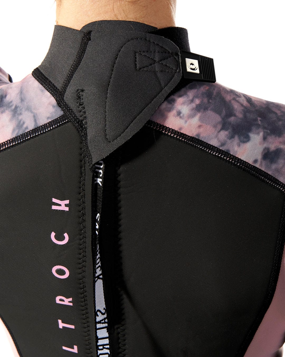 The back view of a woman wearing a Saltrock Vision - Womens 3/2 Back Zip Wetsuit in Black/Pink.