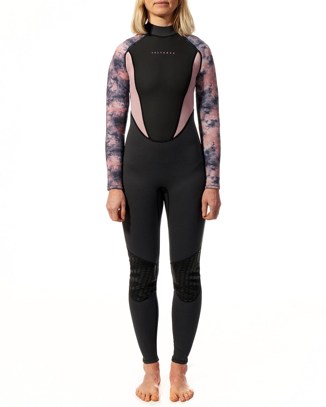 A woman wearing a Saltrock Vision - Womens 3/2 Back Zip Wetsuit - Black/Pink standing on a white background.