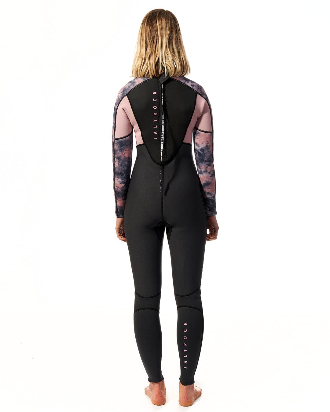 A woman wearing a Saltrock Vision - Womens 3/2 Back Zip Wetsuit - Black/Pink.