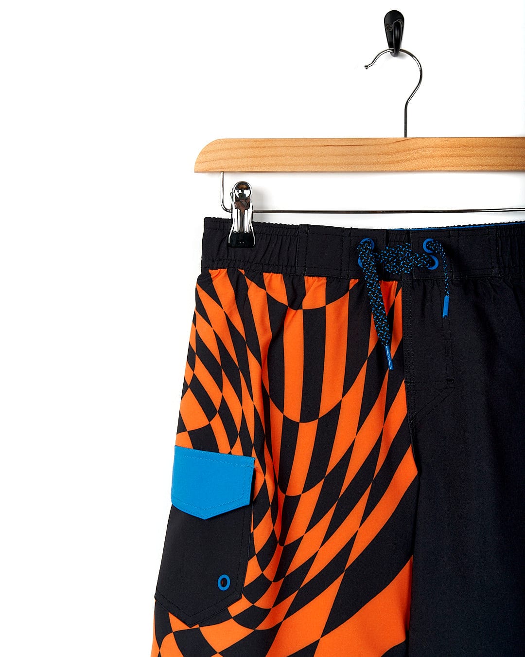 A Saltrock "Warped - Kids Boardshort - Black" hanging on a hanger.