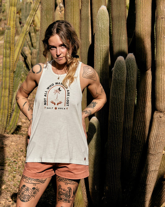 Woman with tattoos posing in front of tall cacti, wearing a Saltrock Palmera - Womens Vest - White and shorts.